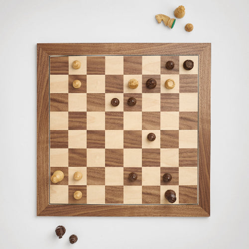 A wooden chess board with scattered chess pieces and nuts, creating a casual and playful atmosphere.